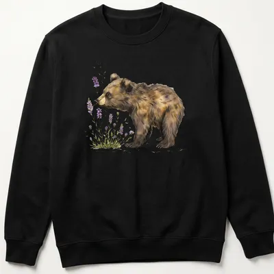 Watercolor illustration of a bear cub sniffing lavender flowers in soft colors — printed on a unisex sweatshirt