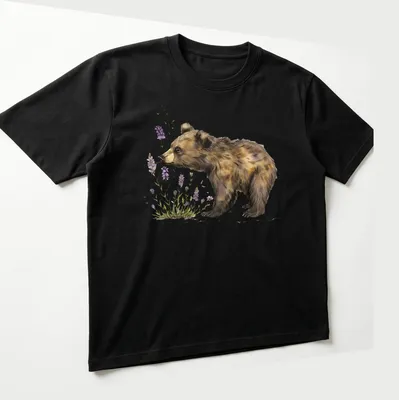 Watercolor illustration of a bear cub sniffing lavender flowers in soft colors — printed on a unisex t-shirt (angled view)