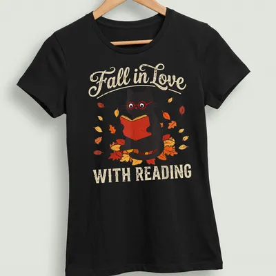 Retro design featuring a black cat with fall leaves and the text 'Fall in Love WITH READING' — printed on a women's shirt