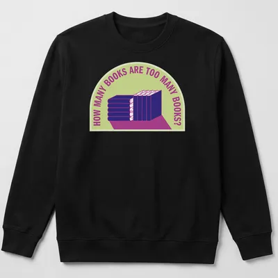 Bold typography t-shirt with humorous text about book collecting over a stack of books — printed on a unisex sweatshirt
