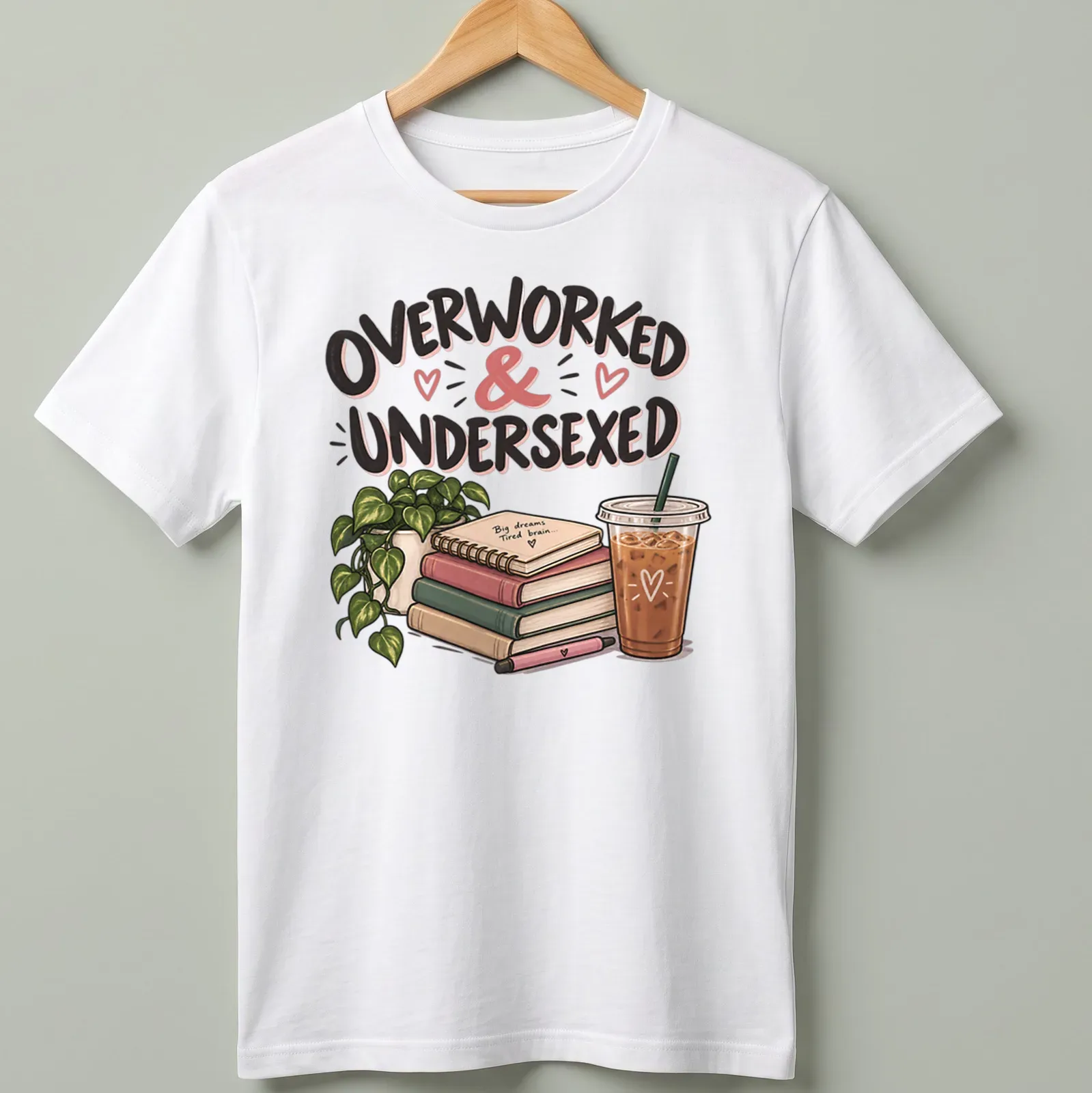 Illustrative design featuring books and coffee with the phrase 'Overworked & Undersexed' in fun typography — printed on a unisex t-shirt