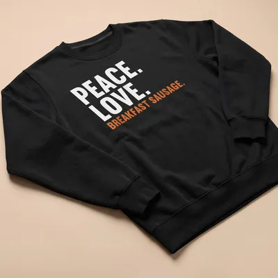 Bold text design featuring 'Peace. Love. Breakfast Sausage.' on a white tee. — printed on a unisex sweatshirt
