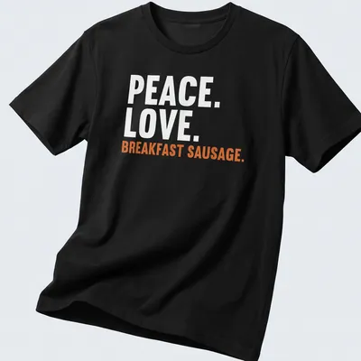 Bold text design featuring 'Peace. Love. Breakfast Sausage.' on a white tee.