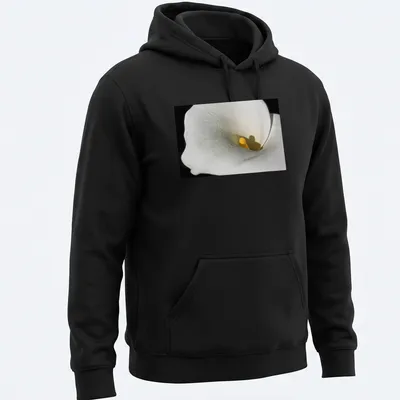 Realistic photography of a Calla Lily in white and yellow against a black background — printed on a unisex hoodie