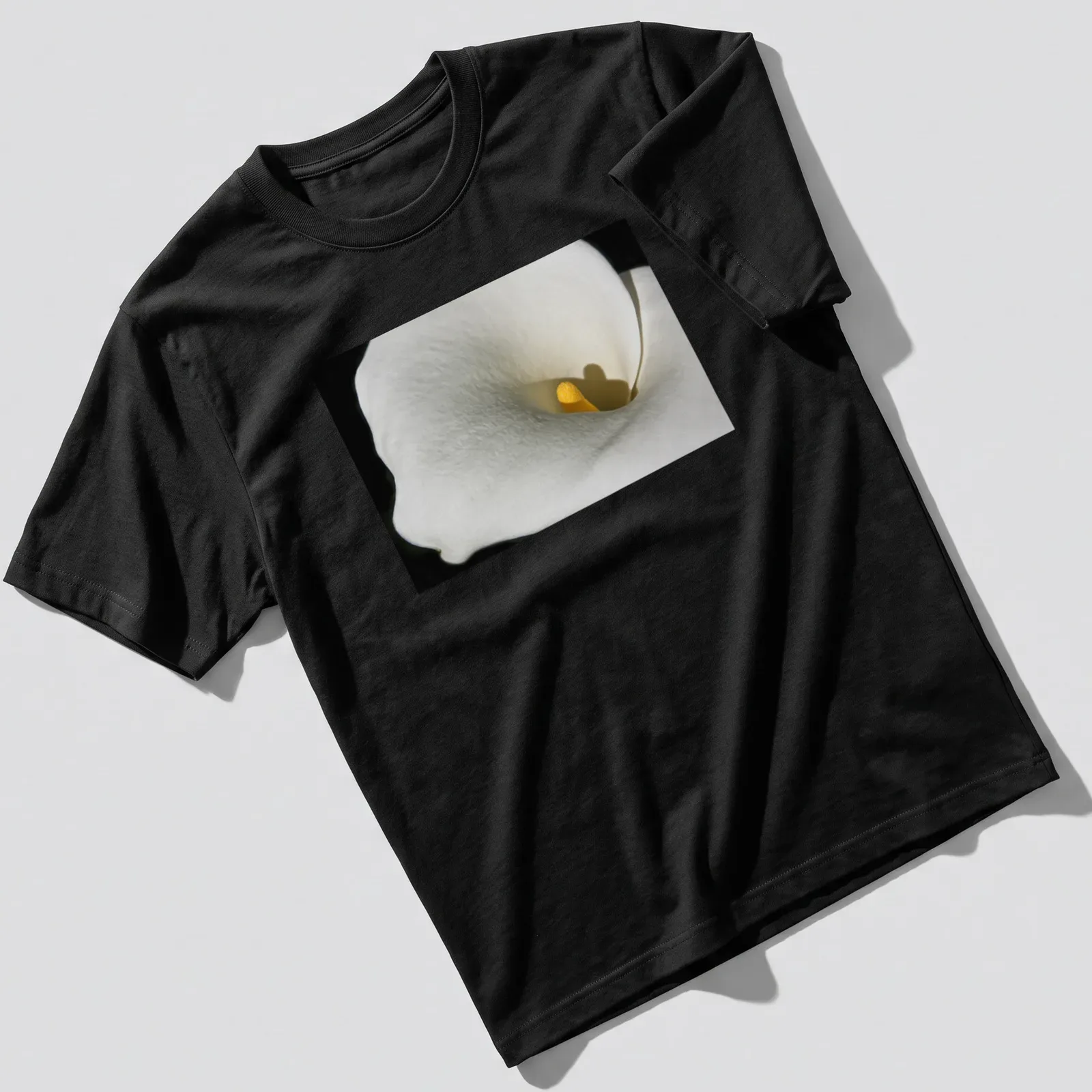 Realistic photography of a Calla Lily in white and yellow against a black background — printed on a unisex t-shirt