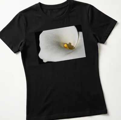 Realistic photography of a Calla Lily in white and yellow against a black background — printed on a women's shirt