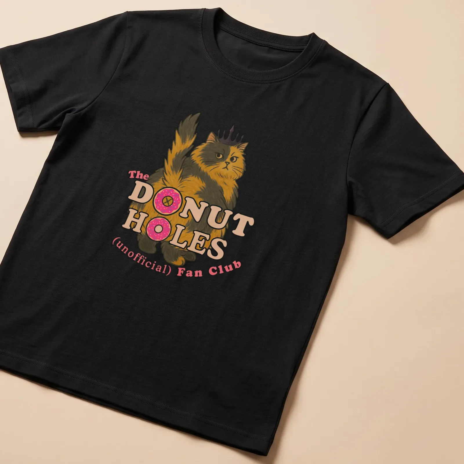 Cartoon cat design with playful text about donut holes in bright colors — printed on a unisex t-shirt