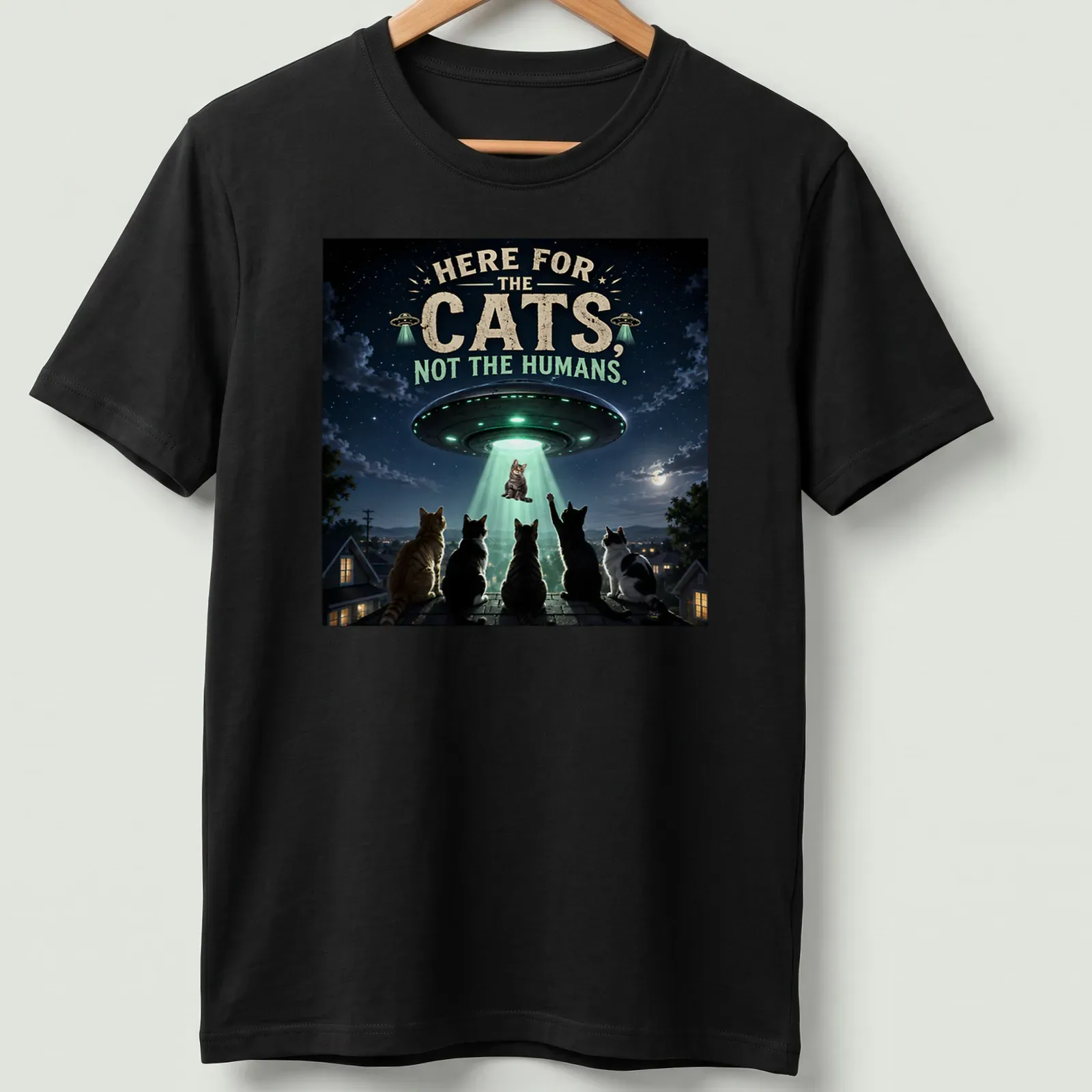 Detailed sci-fi print of cats being abducted by a UFO, with playful text. — printed on a unisex t-shirt