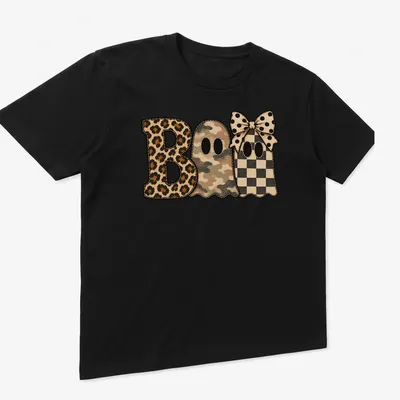 Whimsical patchwork shirt featuring cute ghosts and 'Boo' text in various patterns — printed on a unisex t-shirt (angled view)