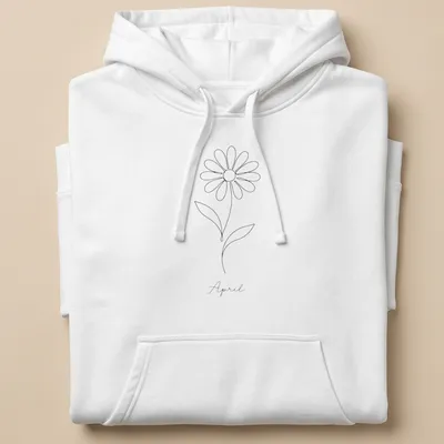Minimalist line art of a daisy and the word April in black and white — printed on a unisex hoodie