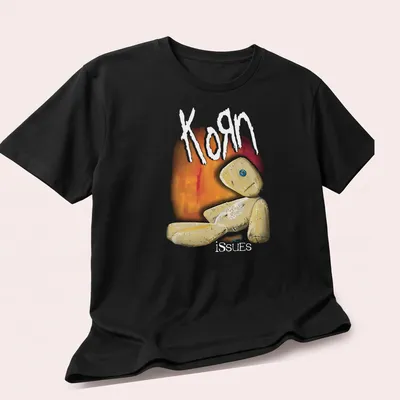 Illustrative print featuring a quirky doll and the text Korn issues in playful colors. — printed on a unisex t-shirt (angled view)
