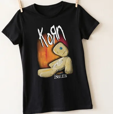 Illustrative print featuring a quirky doll and the text Korn issues in playful colors. — printed on a women's shirt