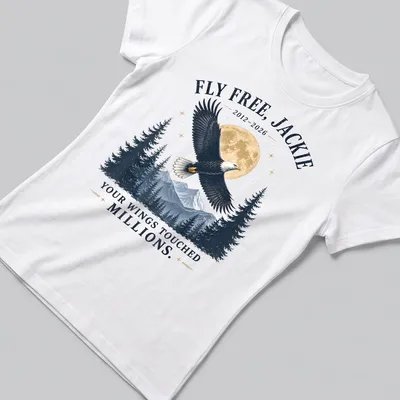 Vintage style t-shirt featuring an eagle with the text FLY FREE, JACKIE 2012-2026 YOUR WINGS TOUCHED MILLIONS. — printed on a women's shirt