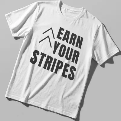 Bold typography t-shirt with the message 'Earn Your Stripes' in black and white.