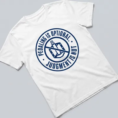 Bold typography shirt featuring the phrase 'PEDALING IS OPTIONAL, JUDGMENT IS NOT' with bike graphics