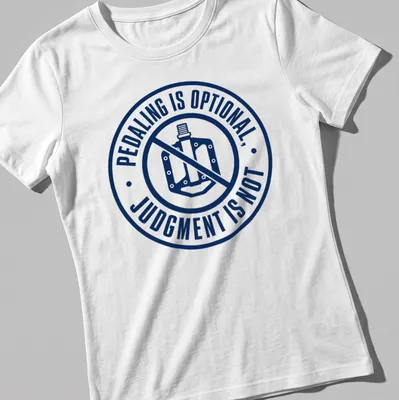 Bold typography shirt featuring the phrase 'PEDALING IS OPTIONAL, JUDGMENT IS NOT' with bike graphics — printed on a women's shirt
