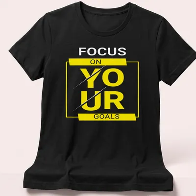 Bold typography shirt with motivational text 'FOCUS ON YOUR GOALS' in yellow, black, and white. — printed on a women's shirt