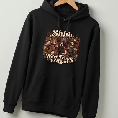 Gothic monsters reading with whimsical text on a dark-themed — printed on a unisex hoodie