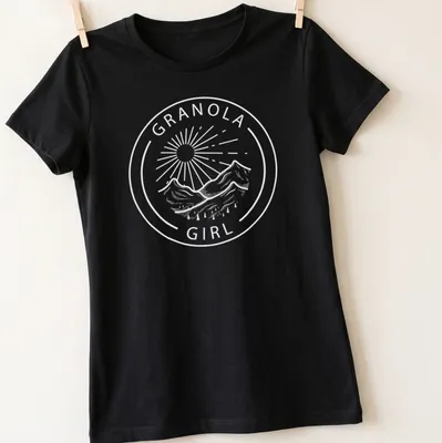 Illustration of a Granola Girl hiking in nature with mountains in the background — printed on a women's shirt