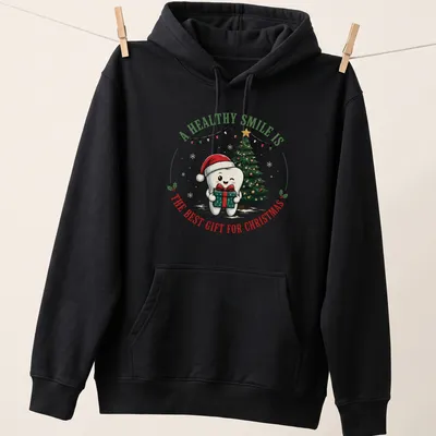Cute cartoon tooth character with a Christmas tree and text about healthy smiles — printed on a unisex hoodie
