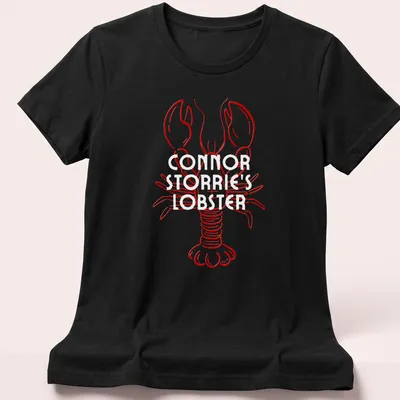 Line-art lobster illustration in red on a T-shirt resembling a magazine cover — printed on a women's shirt