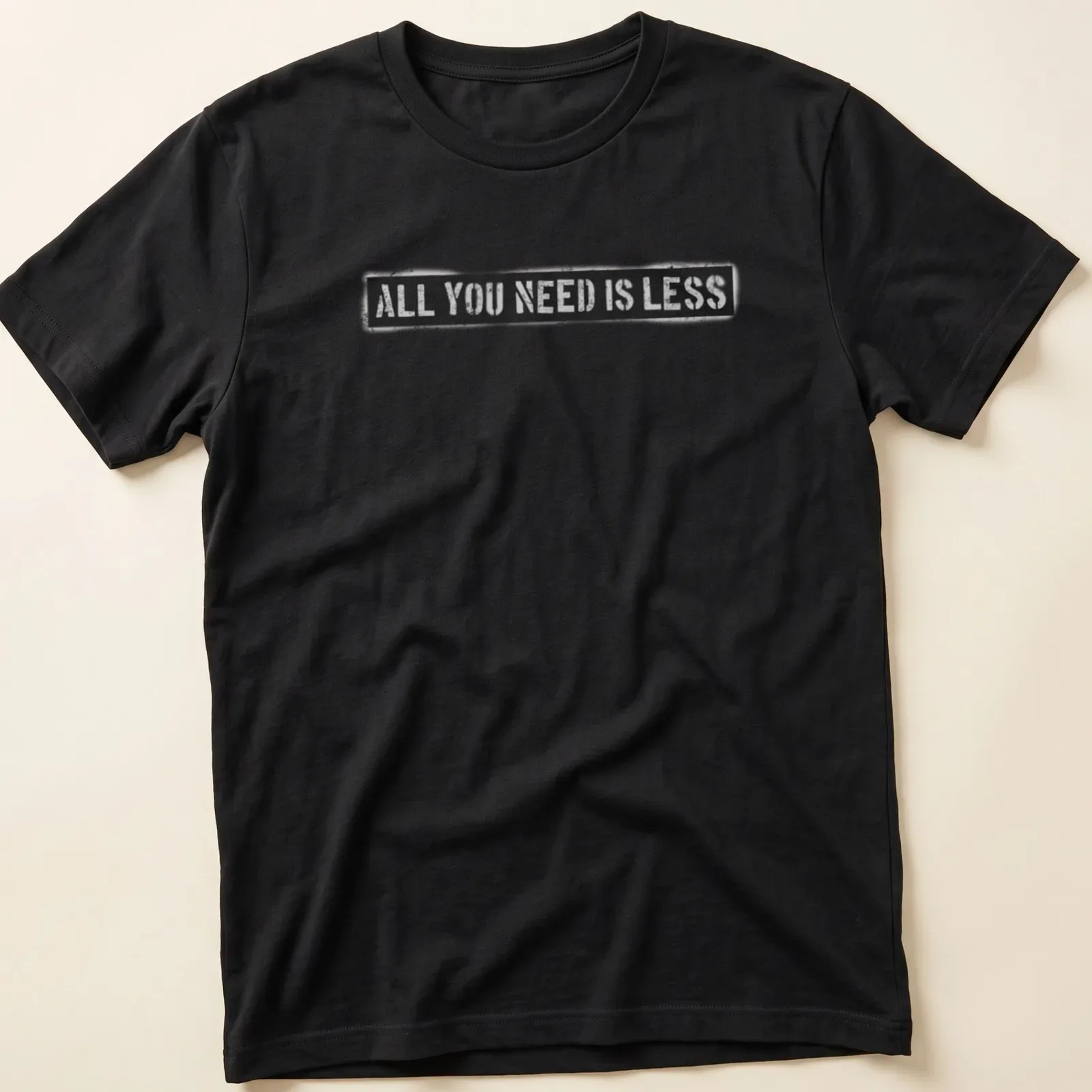 Minimalist design t-shirt with text reading 'All You Need Is Less' in simple typography. — printed on a unisex t-shirt