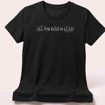 Minimalist design t-shirt with text reading 'All You Need Is Less' in simple typography. — printed on a women's shirt