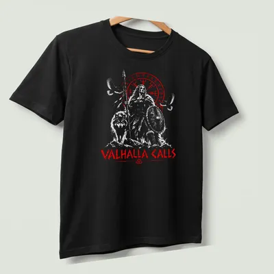 Norse-inspired shirt with Odin, a wolf, and a raven under the words Valhalla Calls — printed on a unisex t-shirt (angled view)