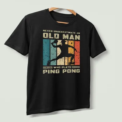 Vintage distressed tee featuring an old man playing ping pong with humorous text — printed on a unisex t-shirt (angled view)