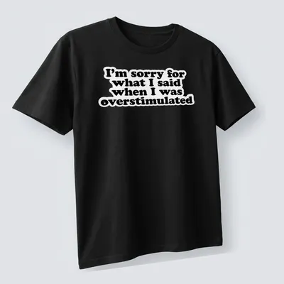 Bold typography t-shirt in black and white with an apology for overstimulation — printed on a unisex t-shirt (angled view)