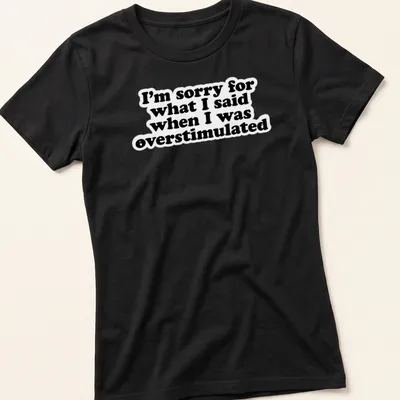Bold typography t-shirt in black and white with an apology for overstimulation — printed on a women's shirt