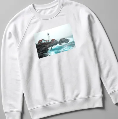 Photographic print of a lighthouse enduring ocean storm waves in blue and gray — printed on a unisex sweatshirt