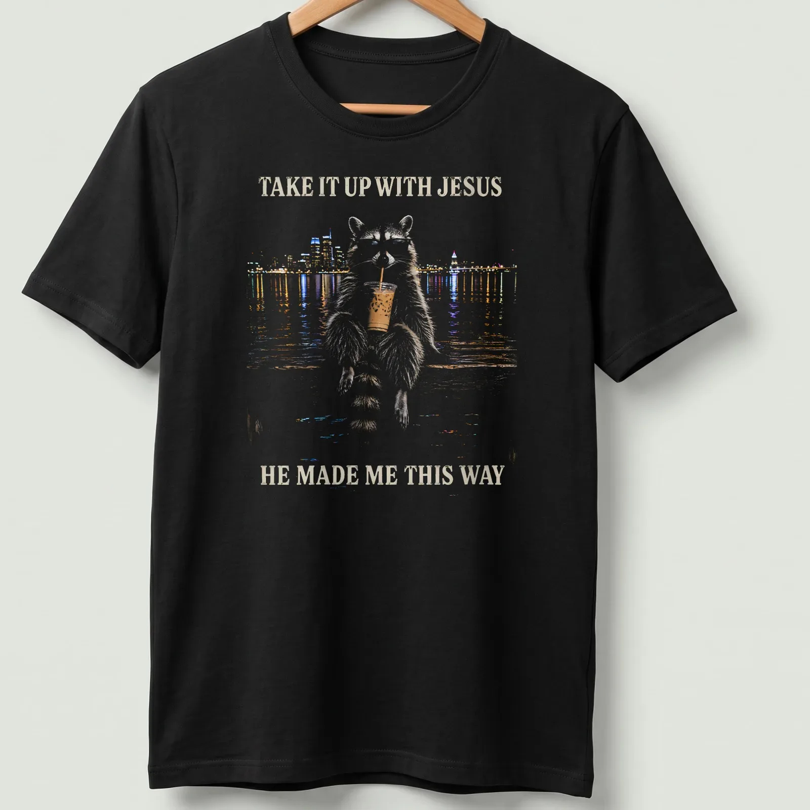 Stylized illustration of a cheeky raccoon with humorous text about Jesus. — printed on a unisex t-shirt