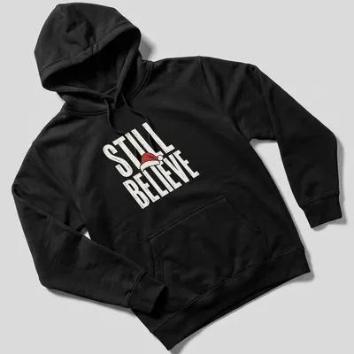 Vintage distressed t-shirt featuring a Santa hat and the phrase 'Still Believe' in bold letters. — printed on a unisex hoodie