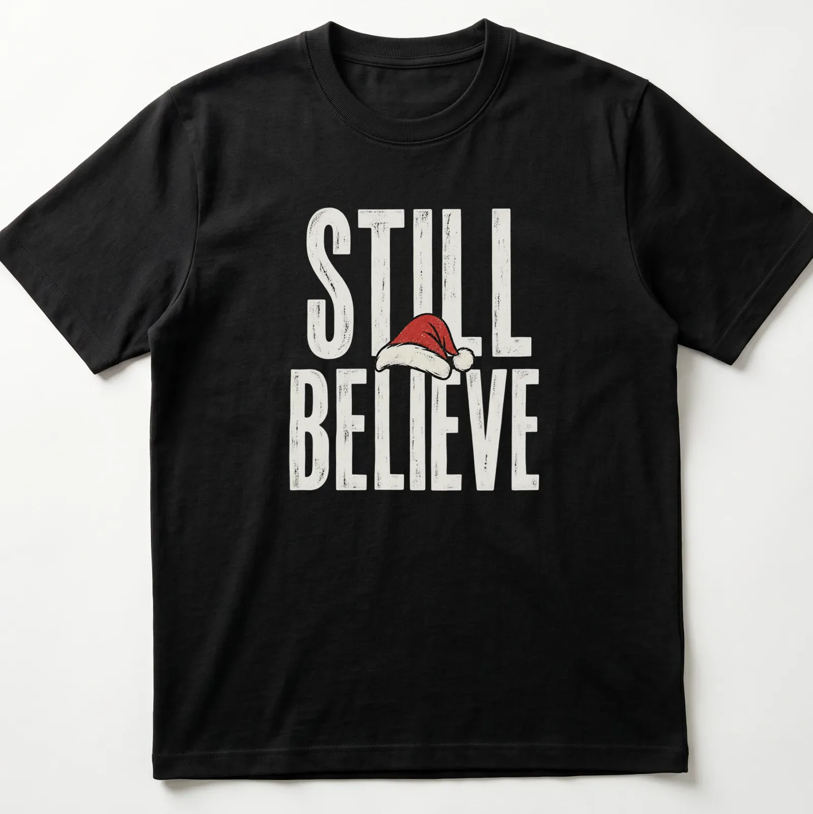 Vintage distressed t-shirt featuring a Santa hat and the phrase 'Still Believe' in bold letters. — printed on a unisex t-shirt