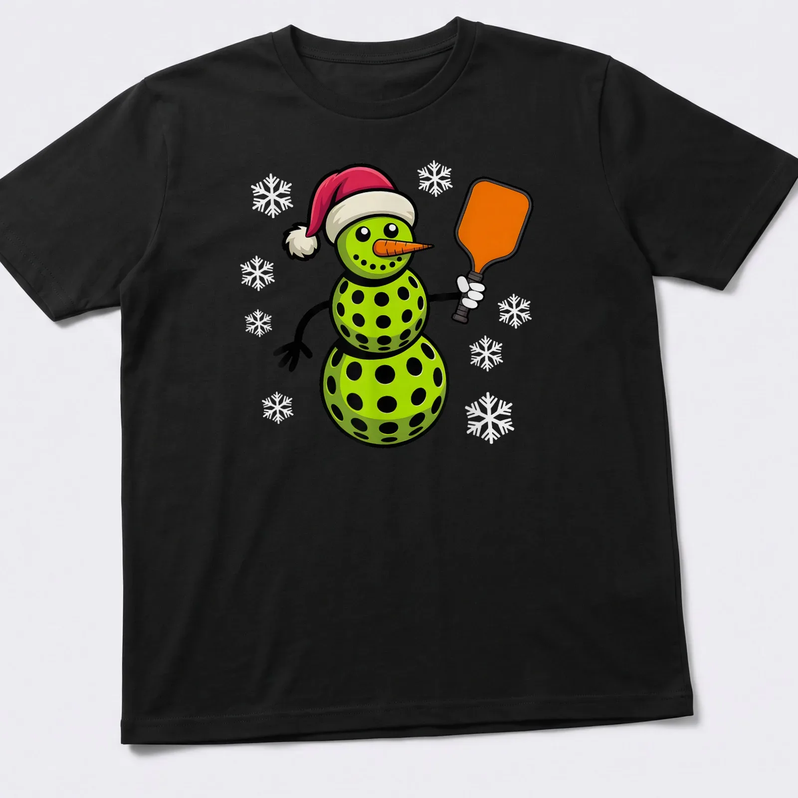Cartoon snowman playing pickleball in red and green with festive colors — printed on a unisex t-shirt
