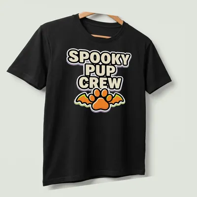 Cartoonish graphic of a dog paw with bat wings and Halloween-themed text — printed on a unisex t-shirt (angled view)