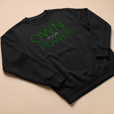 Bold typography shirt with 'OWN YOUR POWER' in dark green and white — printed on a unisex sweatshirt